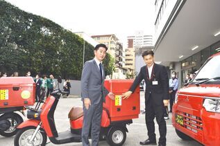 配達用の車両へステッカーを貼る富田市長（左）と東久留米郵便局長　山田氏（右）